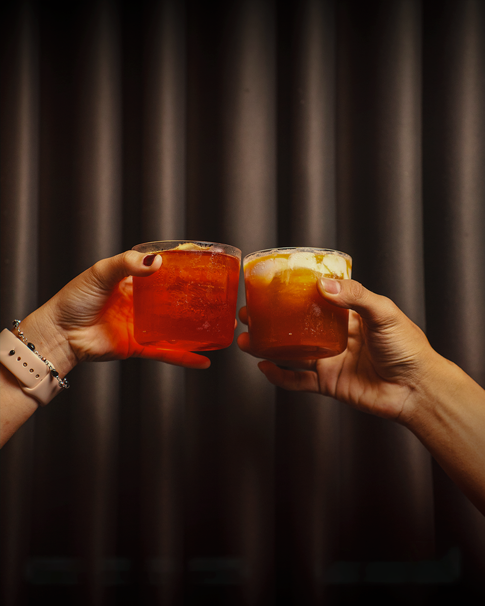 A crimson signature cocktail on dark marble